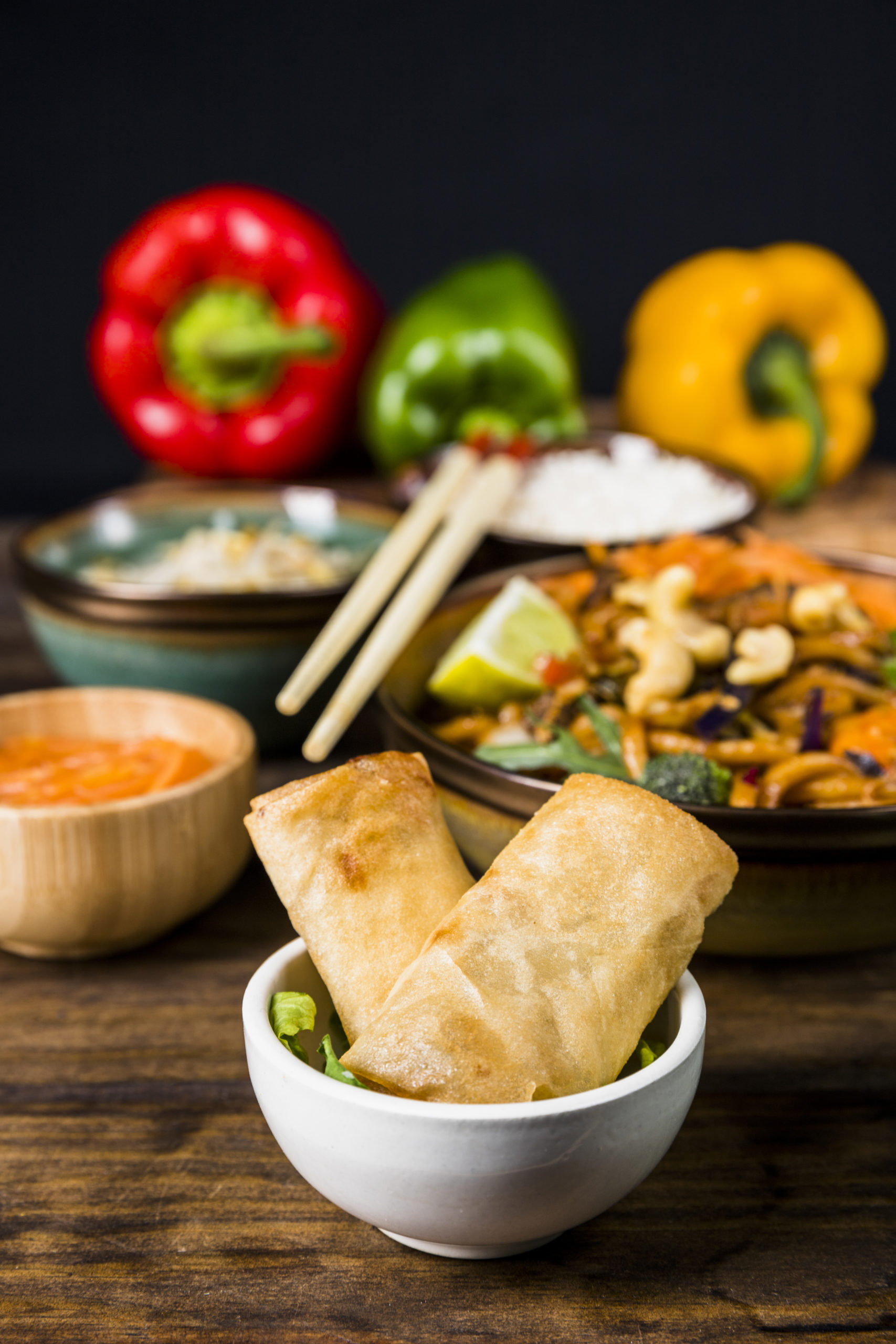 fried-spring-rolls-white-bowl-with-thai-food-wooden-desk